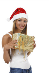 Junge dunkelhaarige Frau mit Weihnachtsmütze und Geschenk