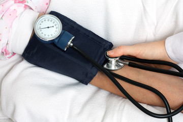 Nurse measuring blood pressure of senior woman