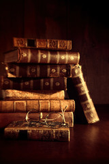 Stack of old books with reading glasses