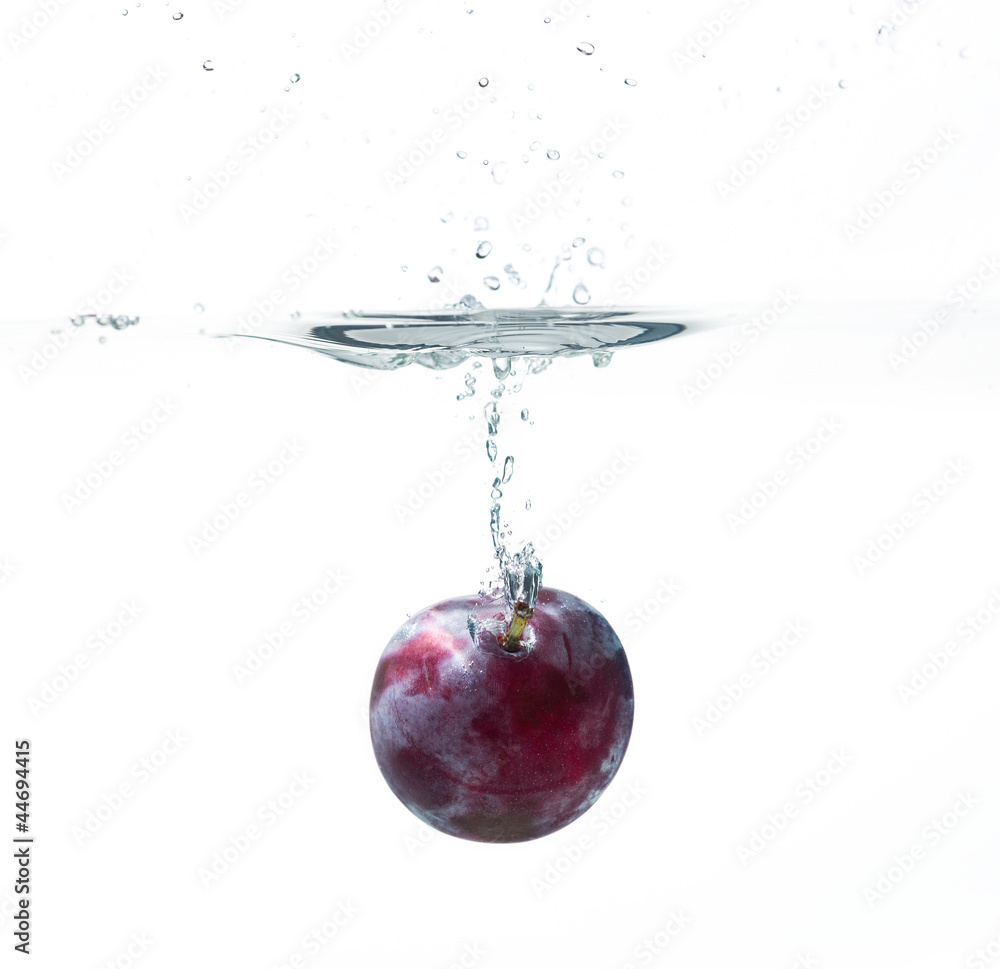 Poster fresh plum in water splash