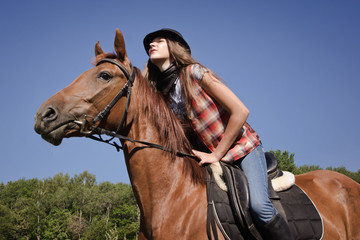 Fototapeta premium Cowgirl riding a bay horse