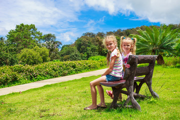 two happy sisters  sitting on the bench