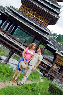 lovely couple. Beauty wearing. Old bridge on the background.