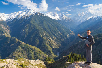 Fototapeta premium businessman with laptop at mountain is pleased