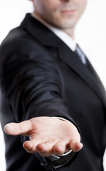 Man in suit holding his hand out