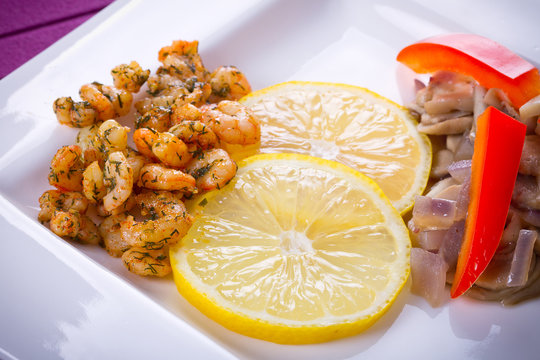 Starter with fried prawns with lemon, mashrooms and brown bread