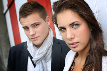 Portrait of couple with serious look standing on sidewalk