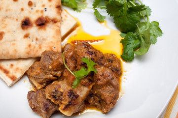 Lamb curry cirrander and Naan close up on a white plate