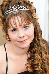 Beauty young Caucasian woman with curly hair and crown on nead