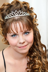 Beauty young Caucasian woman with curly hair and crown on nead