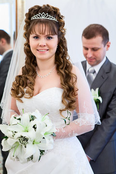Caucasian bride in white dress behind groom