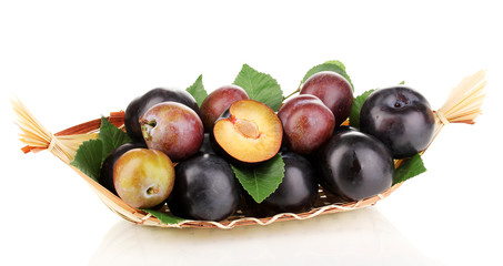 Rip plums on basket isolated on white