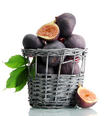 Ripe sweet figs with leaves in basket isolated on white