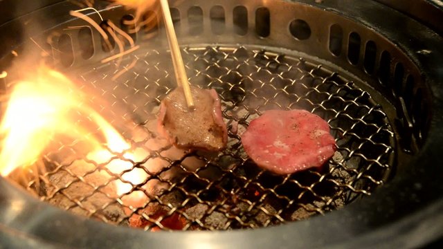 Slice ox tongue on hot charcoal grill with chopstick