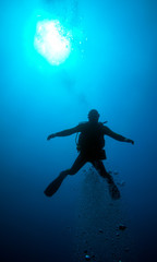 Silhouette of diver with sun disk behind