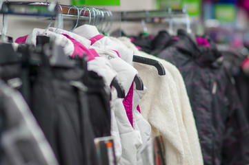 Variety os jackets and vests on stands in supermarket