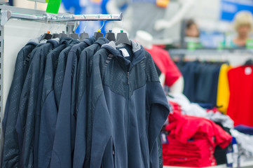 Variety os jackets and vests on stands in supermarket