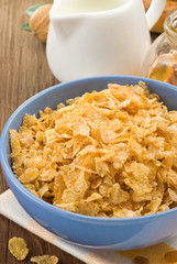 Bowl of corn flakes and milk on wood