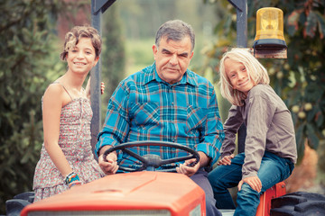 Fototapeta na wymiar Farmer dorosłych z dziećmi na ciągniku