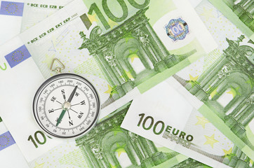 euro bank notes and a compass