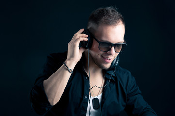 Portrait of man with ear-phones on black background.