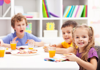Childhood friends eating together in kids room
