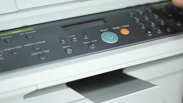 Pessing start button of Grey computer printer