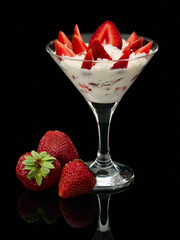 Strawberry whole and with cream in a glass