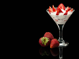 Strawberry whole and with cream in a glass