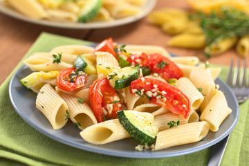 Vegetarian pasta dish with baked zucchini and tomato