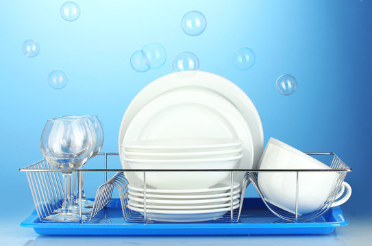 clean dishes on stand on blue background