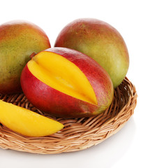Ripe appetizing mango on wicker cradle isolated on white