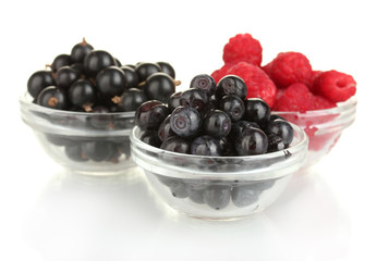 Fresh berries in transparent bowls isolated on white
