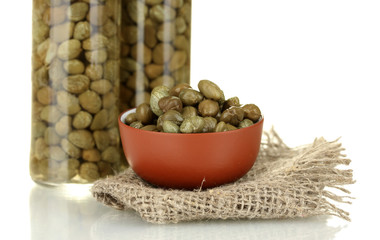 green capers in ceramical bowl on white background