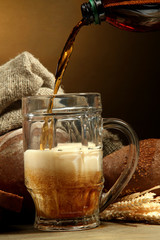 kvass poured into a mug  and rye breads with ears,