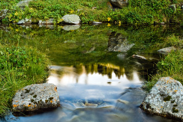 Fototapeta na wymiar Long exposure image of mountain lake falling and flowing trough