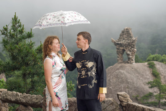 lovely couple with umbrella at cloudy weather in Huangshan