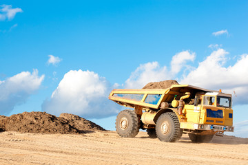 Heavy dump truck unloads soil on the sand at a construction site © Fotolia RAW