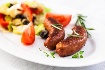 Grilled sausages with salad on a plate