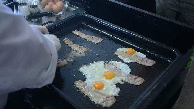 preparing eggs and bacon