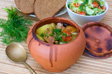 Meat baked with vegetables in rustic clay pot