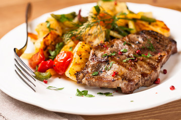 Pork steak with pan-cooked vegetables and fresh herbs