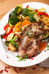 Pork steak with pan-cooked vegetables and fresh herbs