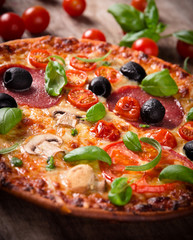 Tasty Italian pizza on wooden background