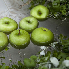 apples sunked in the water with ivy