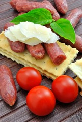 Fototapeta na wymiar Salamini con crackers e scaglie di parmigiano