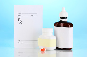 Pharmacist prescription with drops and pills isolated on blue