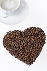 herz aus kaffeebohnen mit tasse
