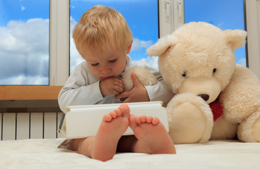 baby and teddy bear with touch pad at home