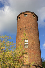 A red brick old industrial tower on blue sky background